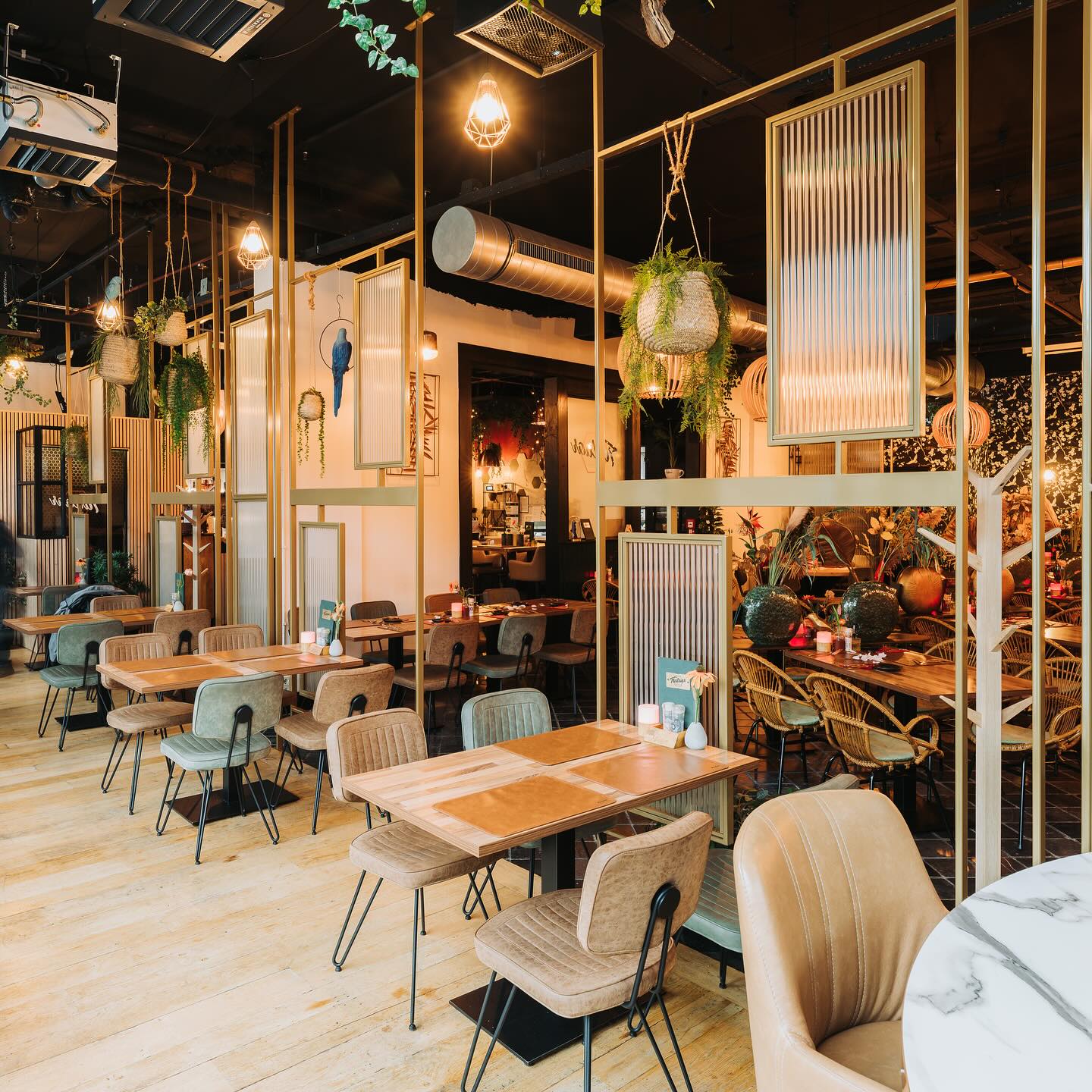 Stalen roomdividers met canuleglas en messing afwerking, uniek ontworpen voor een restaurant, creëren stijlvolle en functionele scheidingen tussen ruimtes.