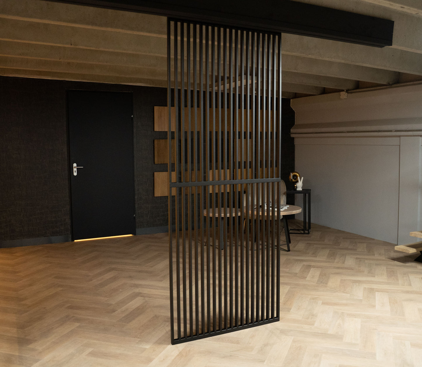 Verticale stalen kokerprofielen vormen een stijlvolle roomdivider, met een strak design dat elegantie en functionaliteit combineert in elk interieur.