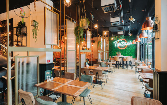 Stalen roomdividers met canuleglas en messing afwerking, uniek ontworpen voor een restaurant, creëren stijlvolle en functionele scheidingen tussen ruimtes.